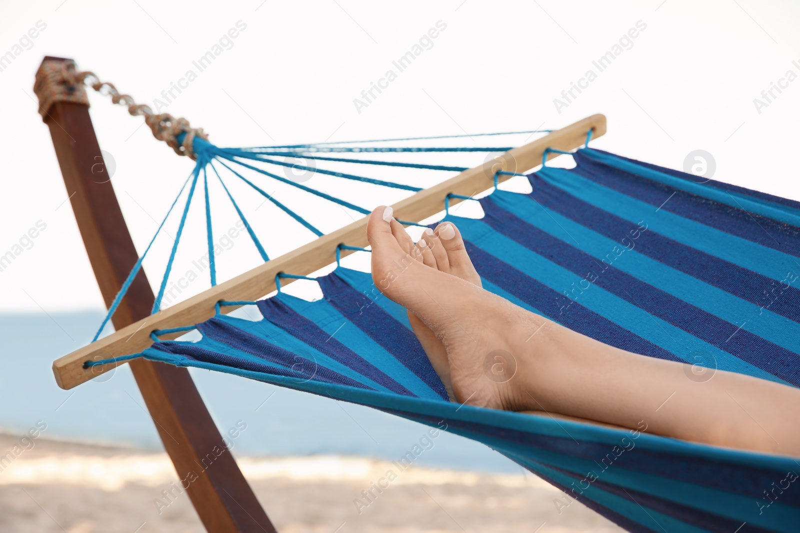 Photo of Young woman resting in hammock at seaside. Summer vacation