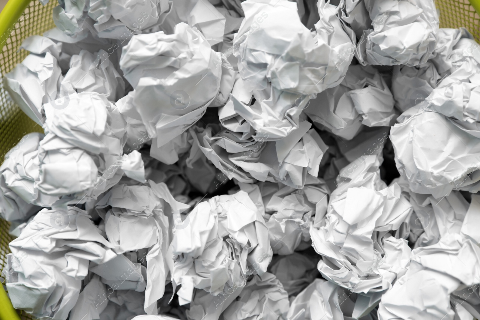 Photo of Closeup of metal bin with crumpled paper, top view