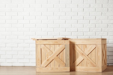 Photo of Wooden crates on floor near brick wall, space for text