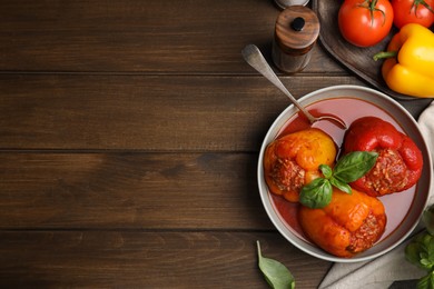 Photo of Delicious stuffed peppers served on wooden table, flat lay. Space for text