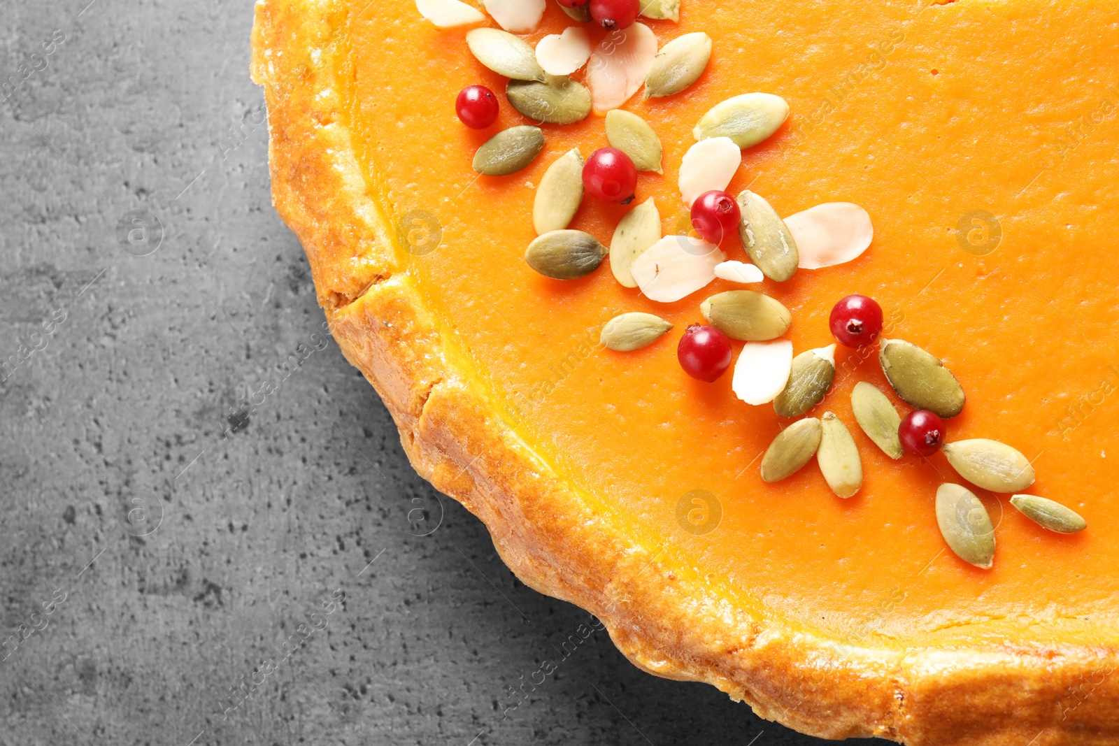 Photo of Fresh delicious homemade pumpkin pie on gray background, top view