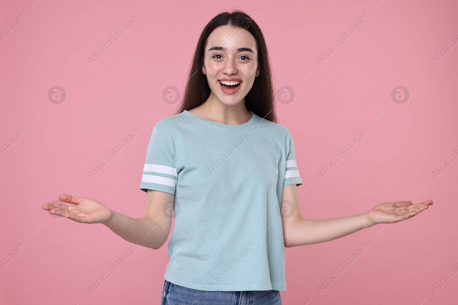 Photo of Portrait of happy surprised woman on pink background