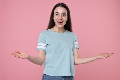 Portrait of happy surprised woman on pink background