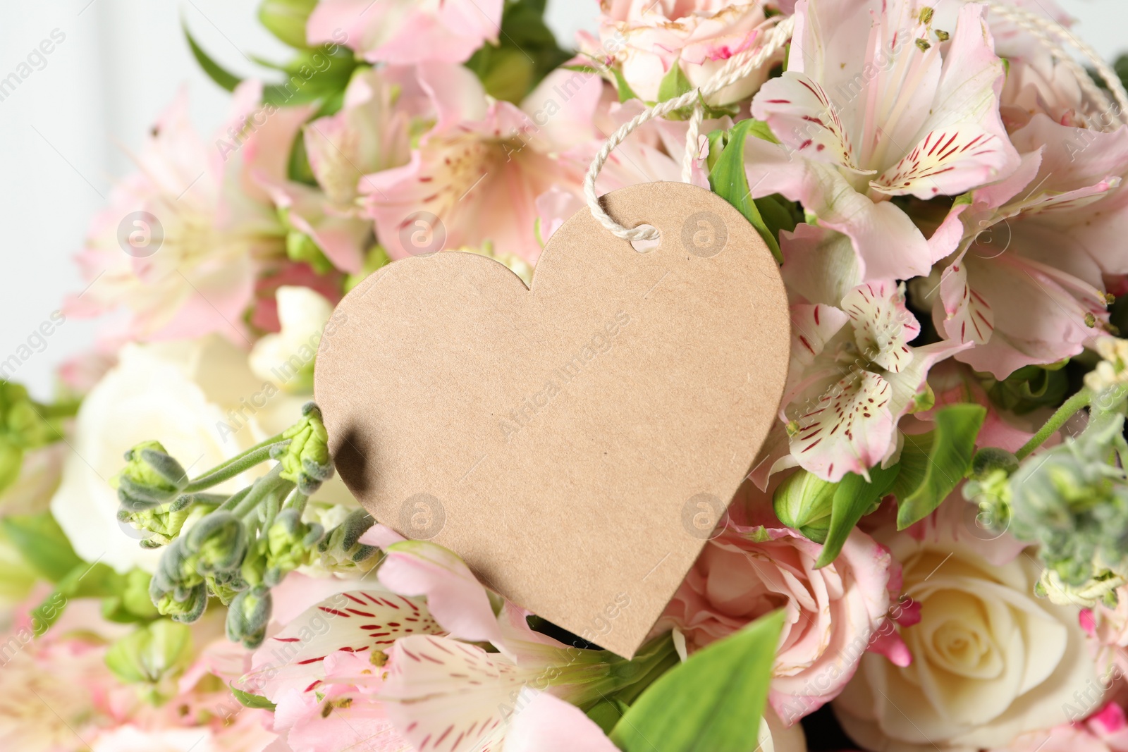 Photo of Happy Mother's Day. Beautiful flowers with blank heart shaped card on light background, closeup