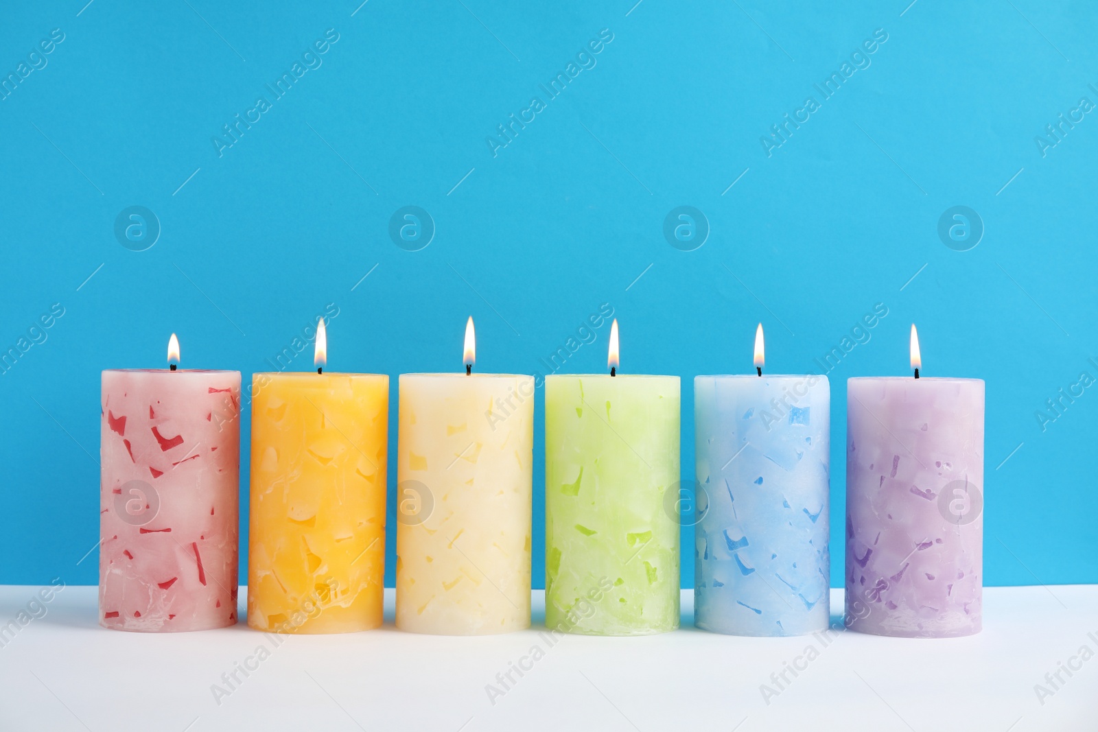 Photo of Alight scented wax candles on color background