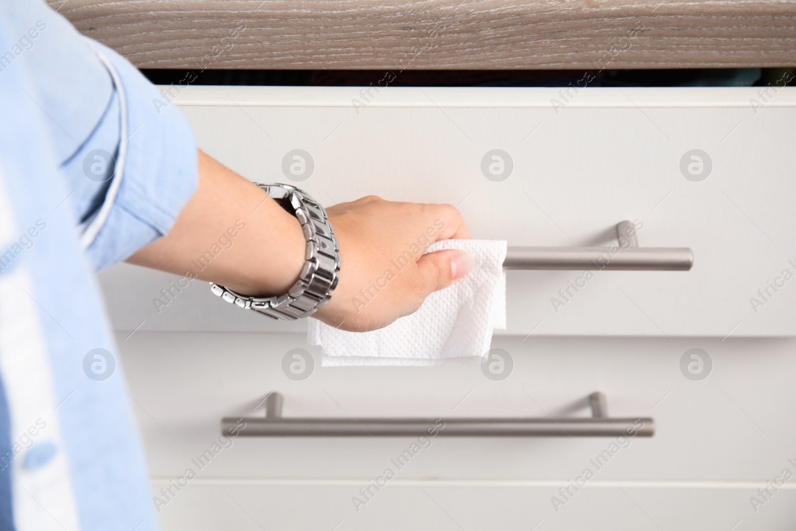 Photo of Woman using tissue paper to open drawer, closeup