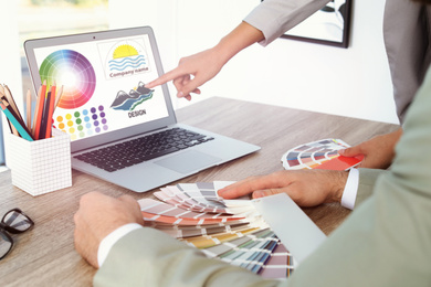 Image of Professional designers working with color palette samples at desk at office table, closeup 
