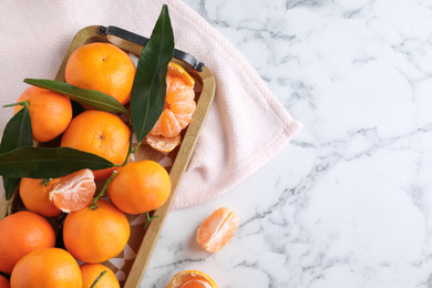 Photo of Fresh ripe tangerines on marble table, flat lay. Space for text