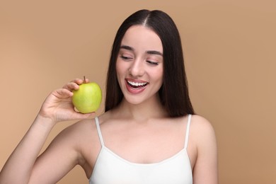 Photo of Beautiful young woman with apple on beige background