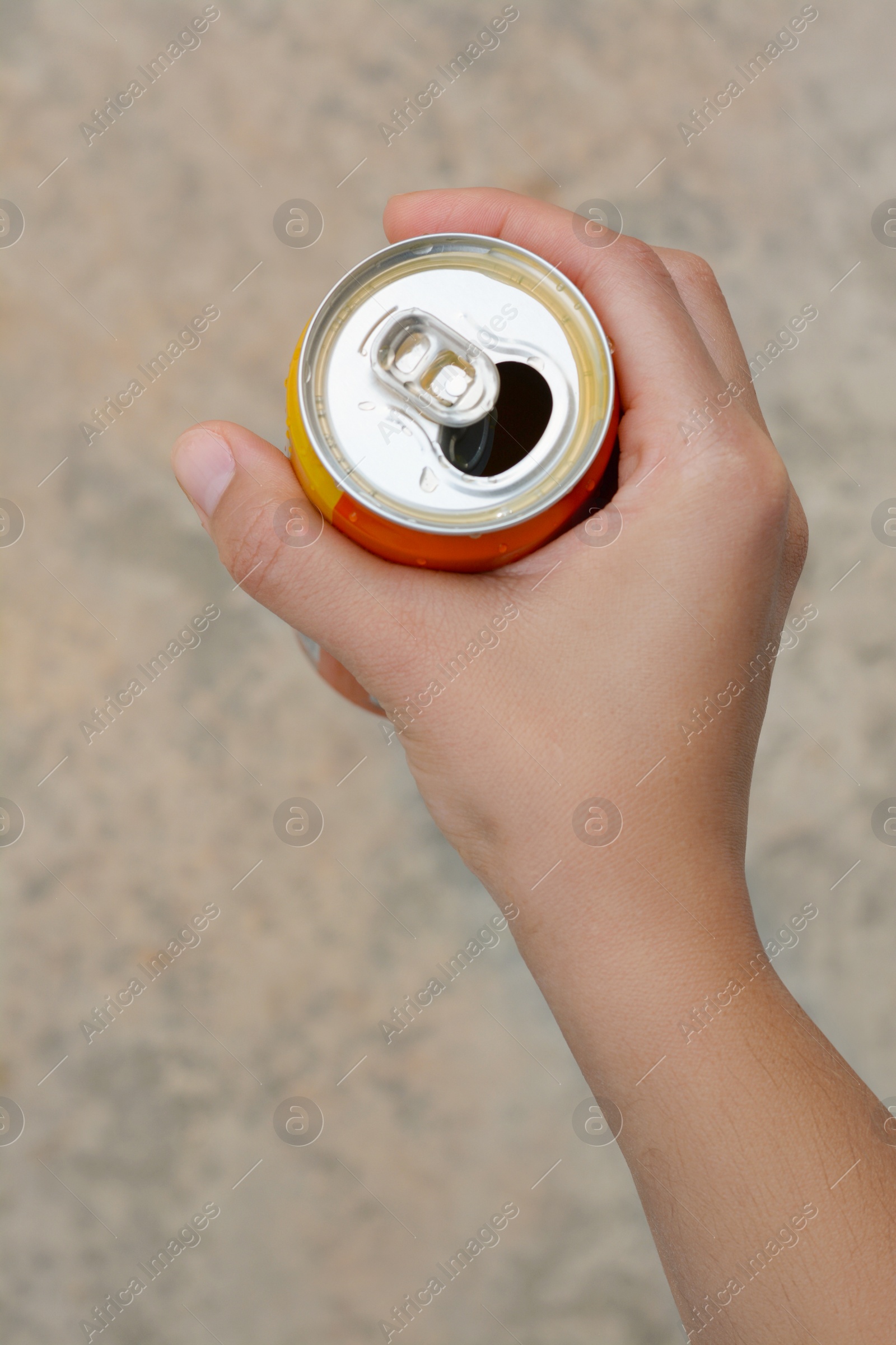 Photo of Woman holding tasty open canned beverage against blurred background, top view