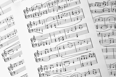 Photo of Music sheets. Melodies written with different musical symbols as background, closeup