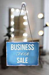 Image of Light blue sign with Business For Sale hanging on glass door