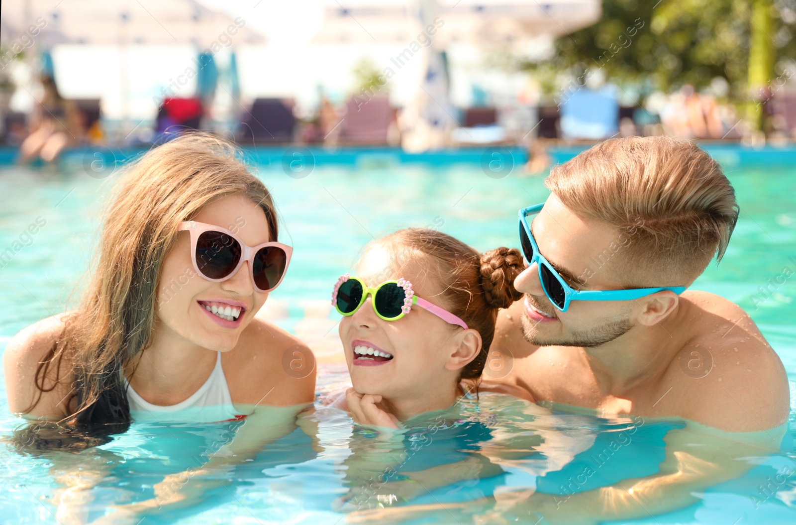 Photo of Happy family in pool on sunny day