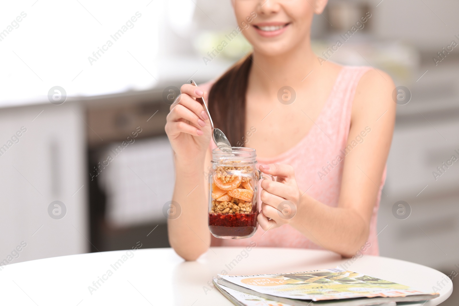 Photo of Young woman in fitness clothes having healthy breakfast at home, closeup