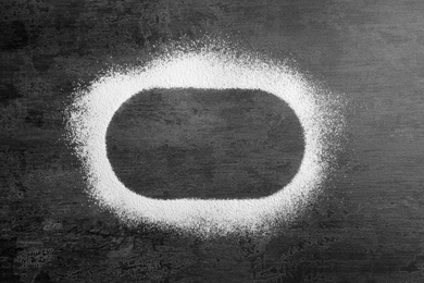 Oval frame made of flour on gray background, top view. Space for text