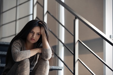 Photo of Depressed young woman sitting on stairs