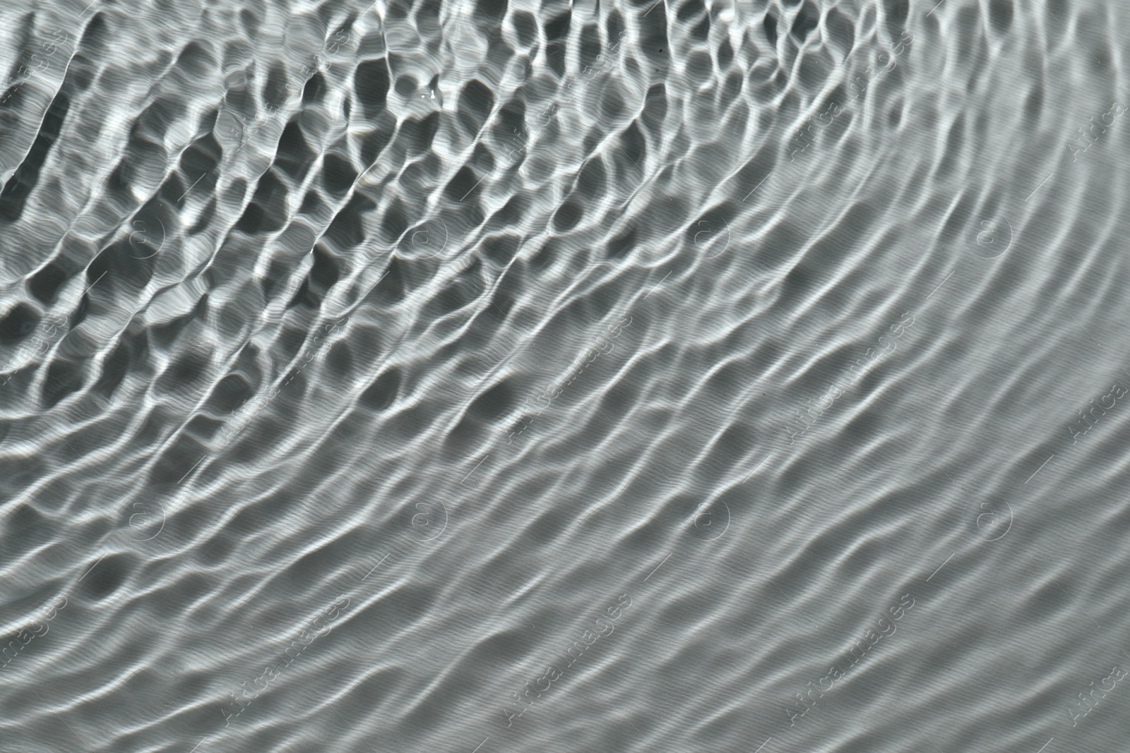 Photo of Rippled surface of clear water on light grey background, top view