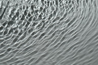 Photo of Rippled surface of clear water on light grey background, top view