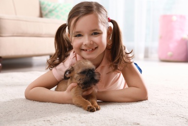 Photo of Portrait of cute girl with funny Brussels Griffon dog at home. Loyal friends