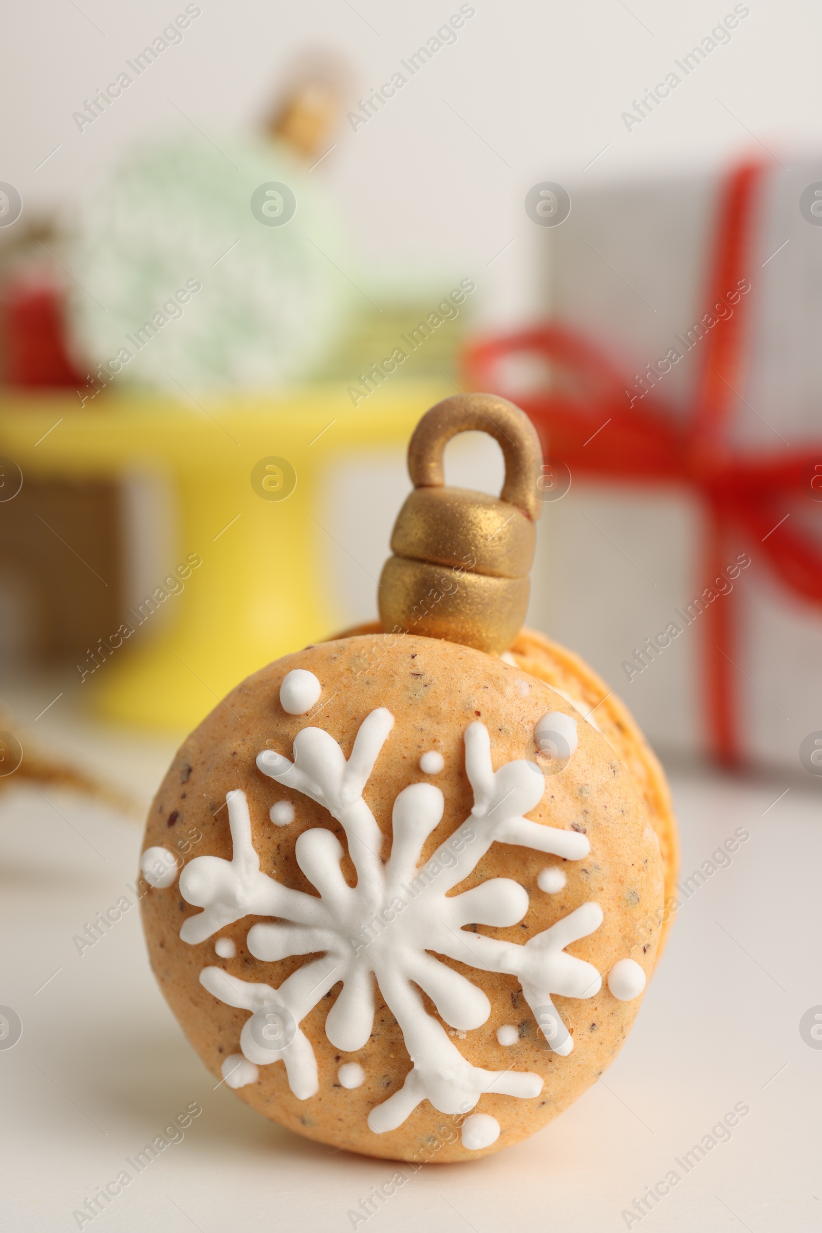 Photo of Beautifully decorated Christmas macaron on white table, closeup