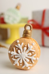 Photo of Beautifully decorated Christmas macaron on white table, closeup
