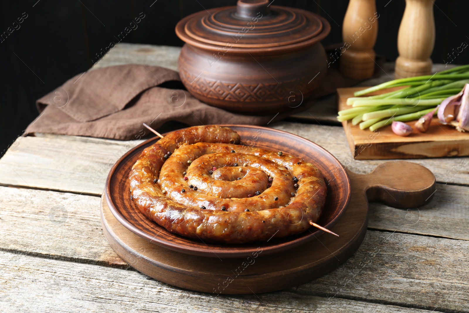 Photo of Plate with tasty homemade sausages on wooden table