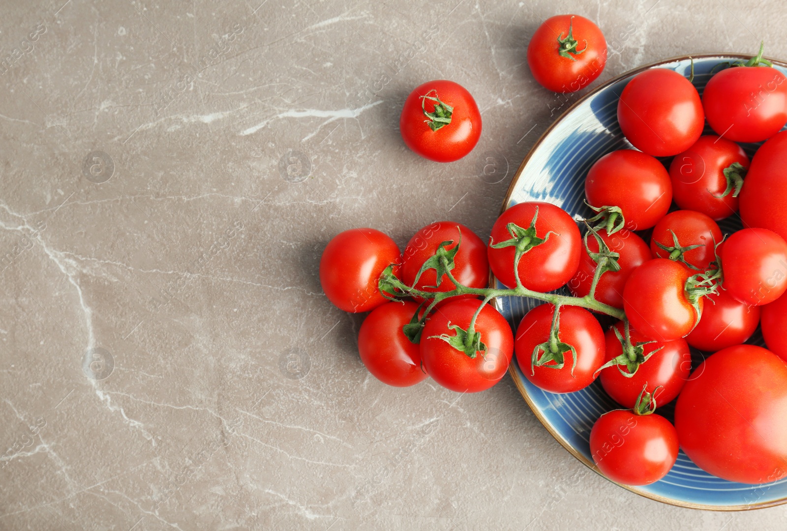 Photo of Plate with fresh ripe tomatoes on grey background, top view