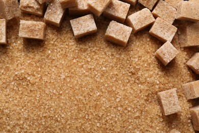 Different types of brown sugar as background, top view. Space for text