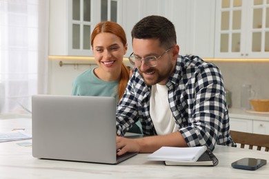 Couple using laptop for paying taxes at home