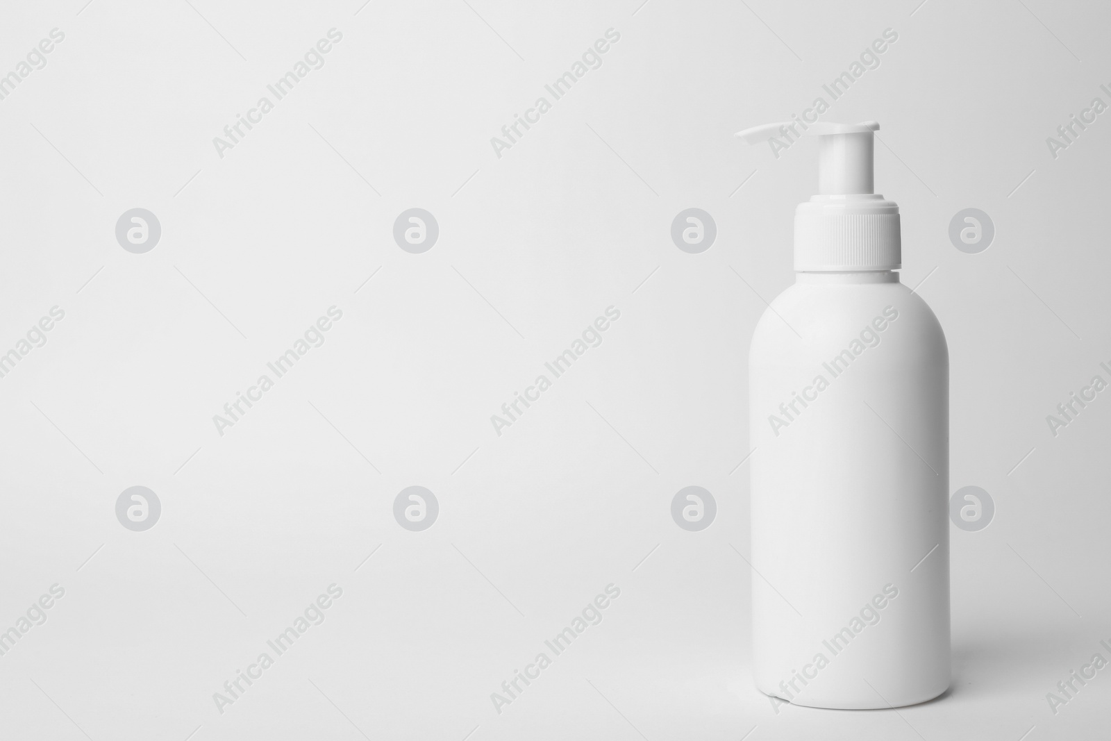 Photo of Bottle of face cleansing product on white background. Space for text