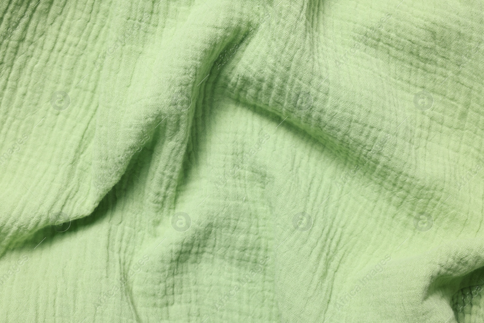 Photo of Texture of green crumpled fabric as background, top view