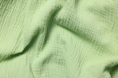 Photo of Texture of green crumpled fabric as background, top view