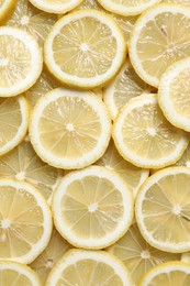 Slices of fresh lemons as background, top view