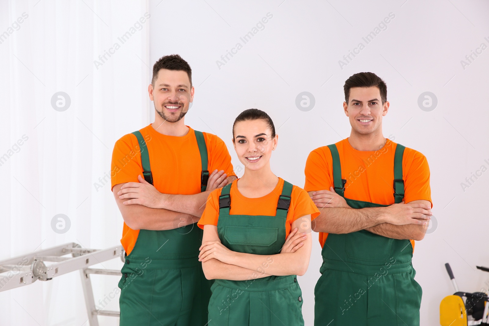 Photo of Team of professional janitors in uniform indoors. Cleaning service