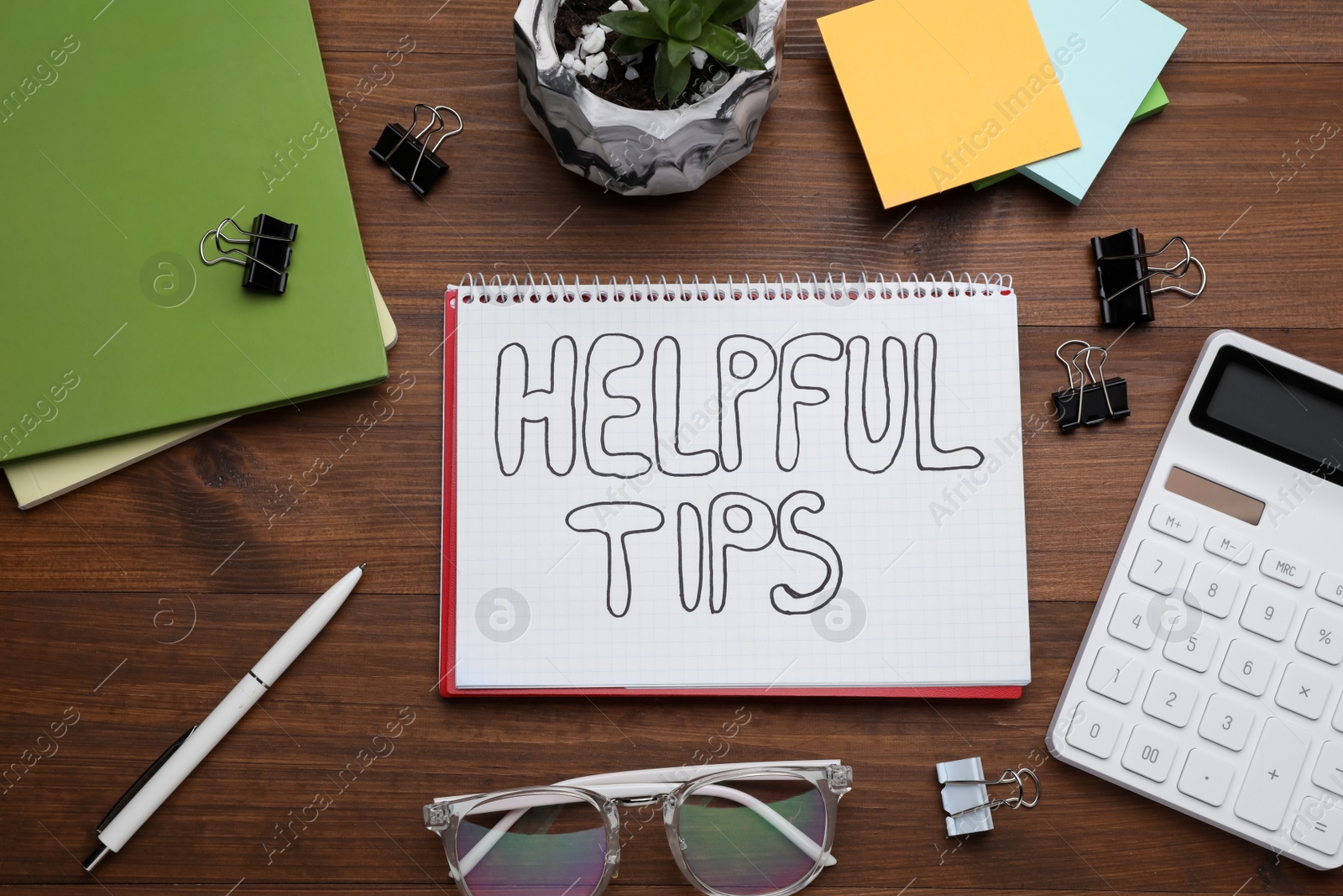 Photo of Helpful Tips. Flat lay composition with notebook, calculator and stationery on wooden table