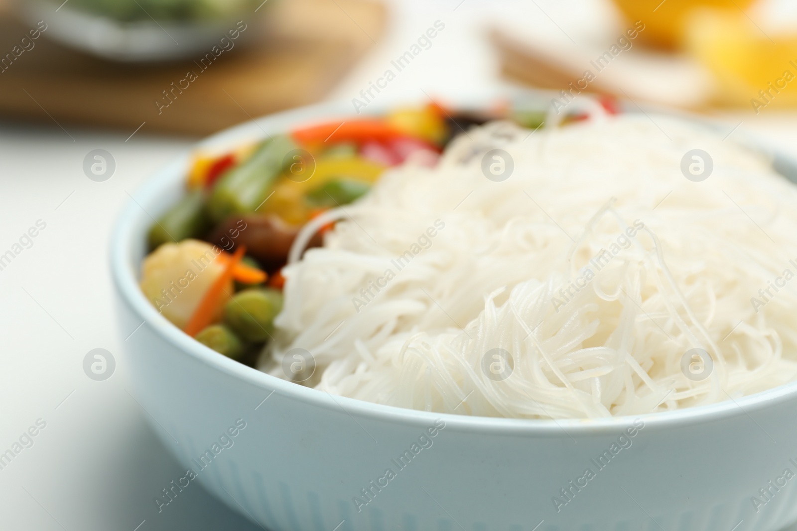 Photo of Tasty cooked rice noodles with vegetables on table, closeup