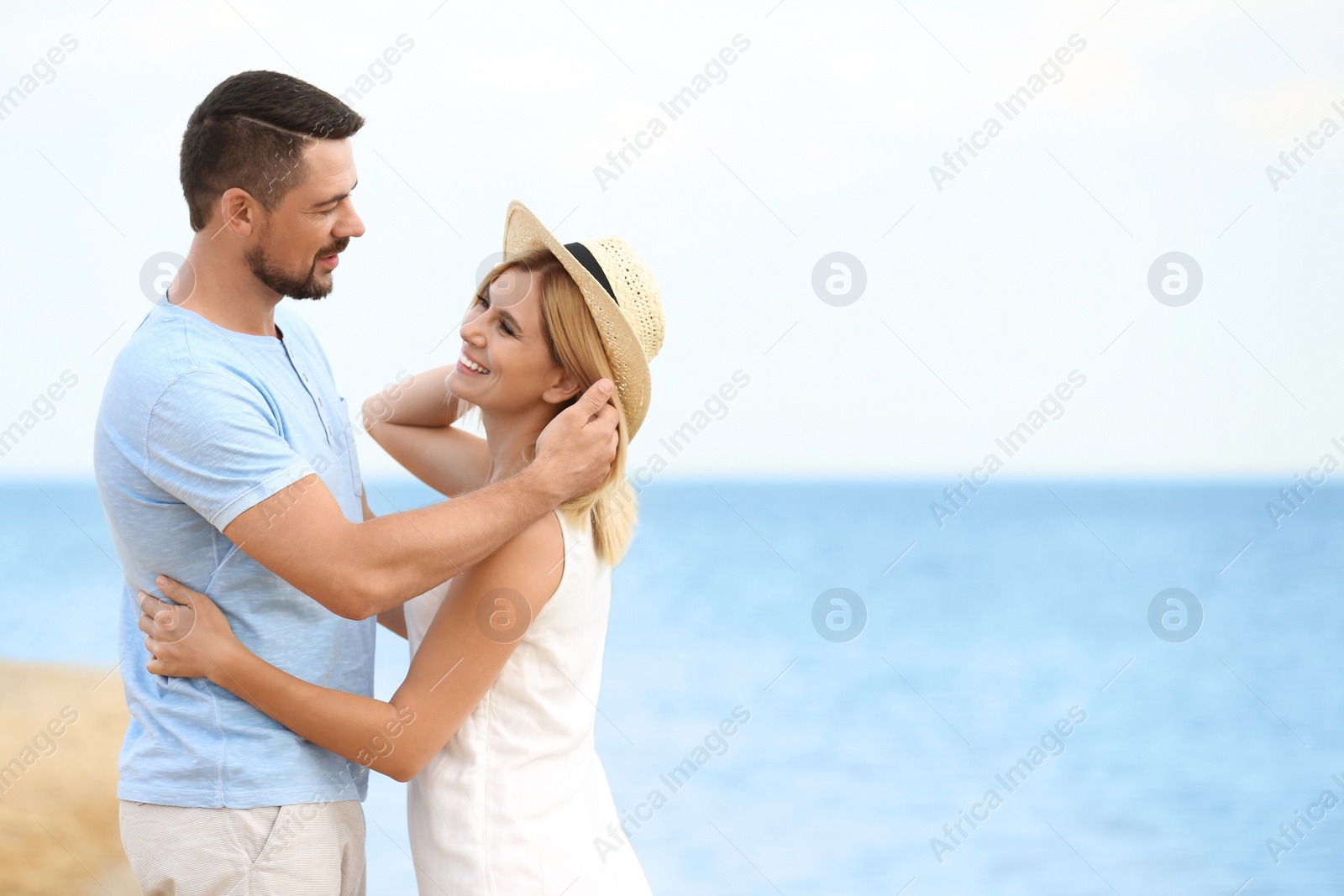 Photo of Happy romantic couple spending time together on beach, space for text