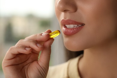 Photo of Young woman taking dietary supplement pill, closeup