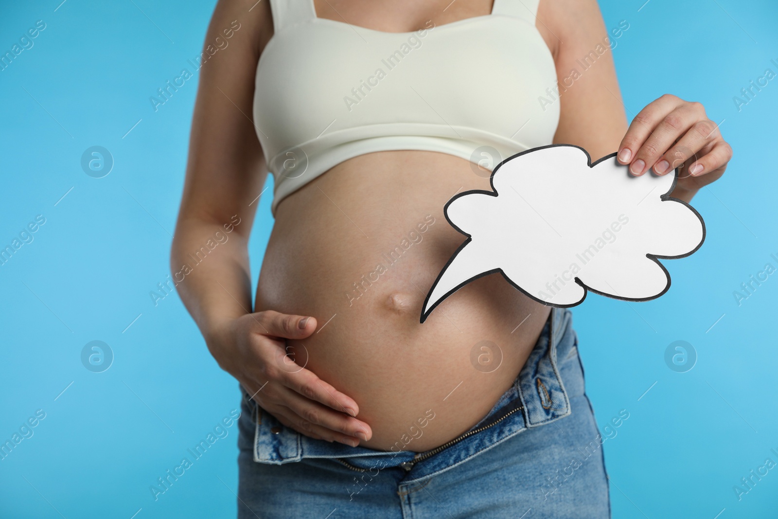 Photo of Pregnant woman with empty paper thought cloud on light blue background, closeup. Choosing baby name