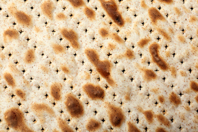 Photo of Traditional Matzo as background, top view. Pesach (Passover) celebration