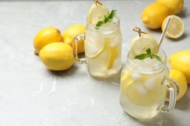 Photo of Natural lemonade with mint and fresh fruits on light grey marble table. Summer refreshing drink