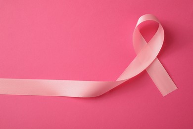 Photo of Pink ribbon on color background, top view. Breast cancer awareness concept