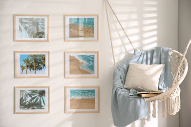 Photo of Different pictures on wall and hanging chair in room. Artworks in interior design