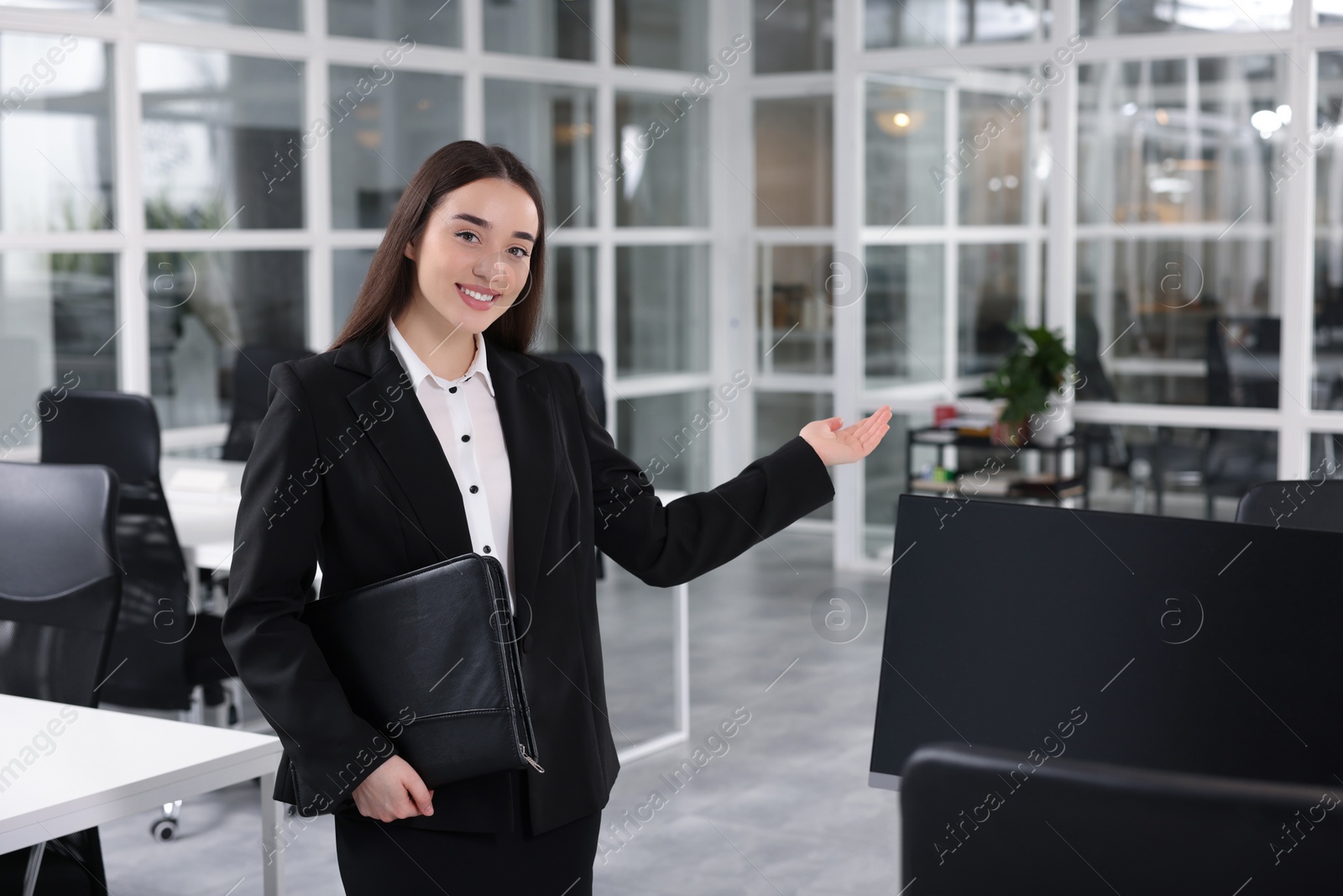 Photo of Happy real estate agent with leather portfolio in office