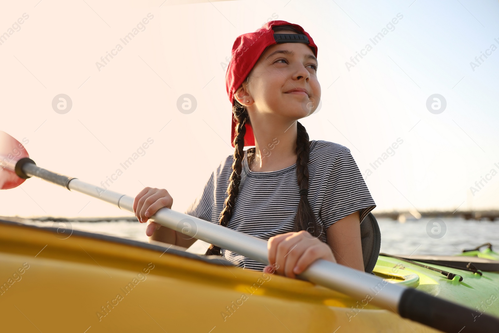 Photo of Happy little girl kayaking on river. Summer camp activity