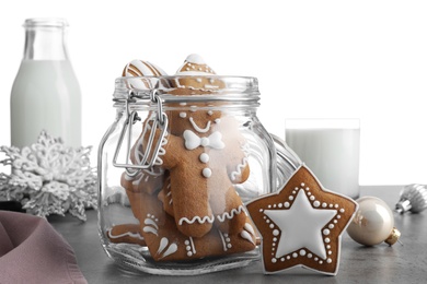 Tasty Christmas cookies and milk on grey table against white background, closeup