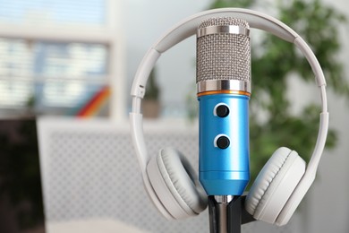 Microphone and modern headphones indoors, closeup. Space for text