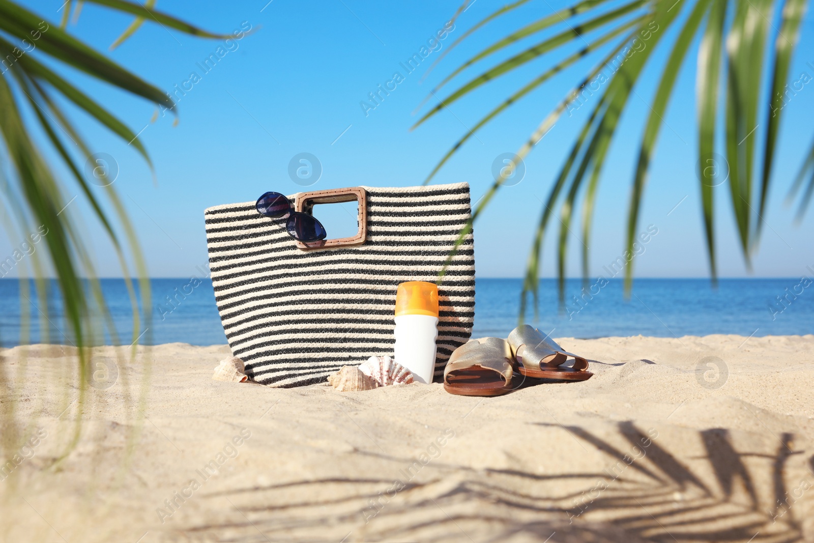 Photo of Stylish beach accessories on sandy sea shore