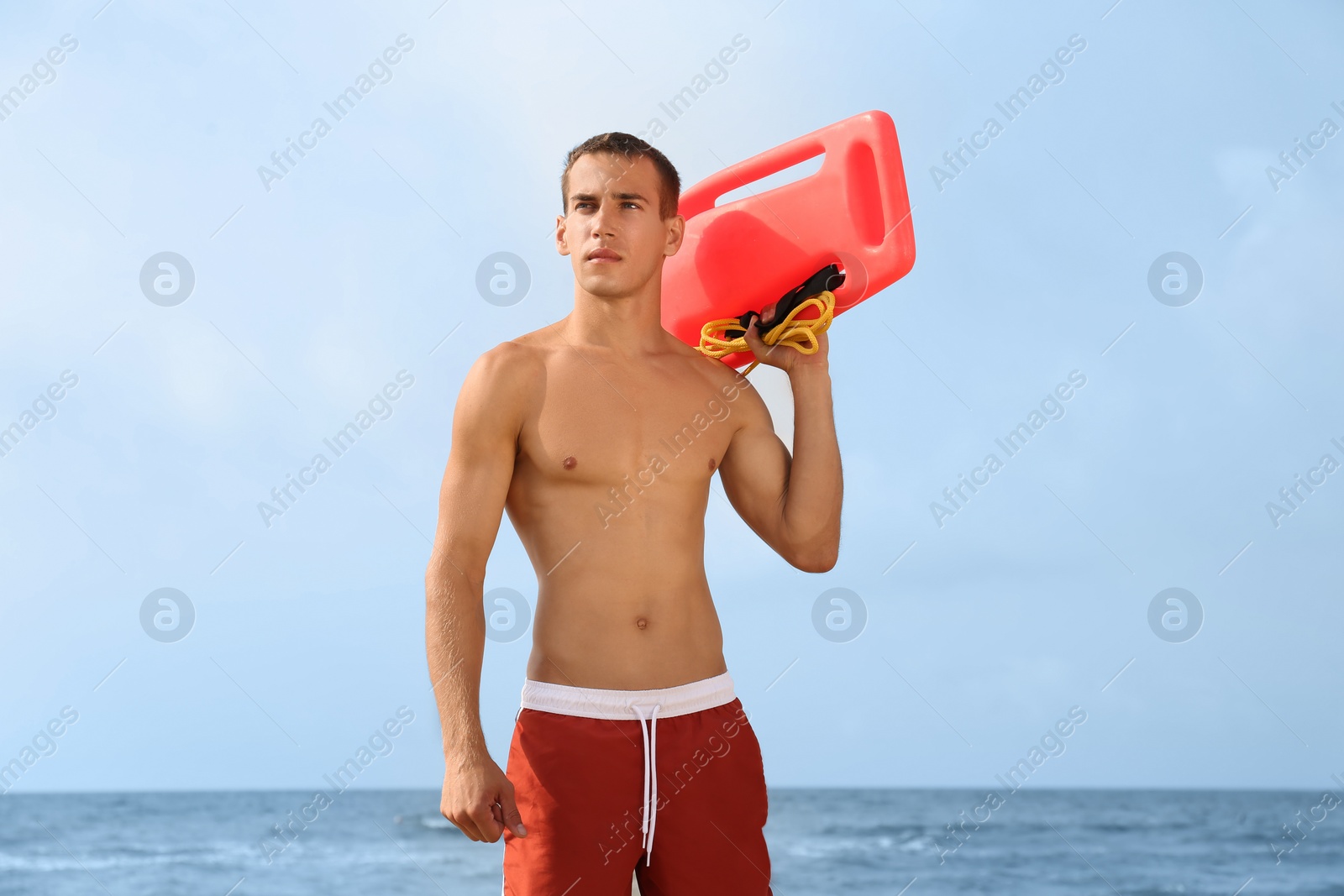 Photo of Handsome lifeguard with life buoy near sea