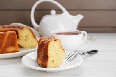 Piece of delicious homemade yogurt cake served on white wooden table